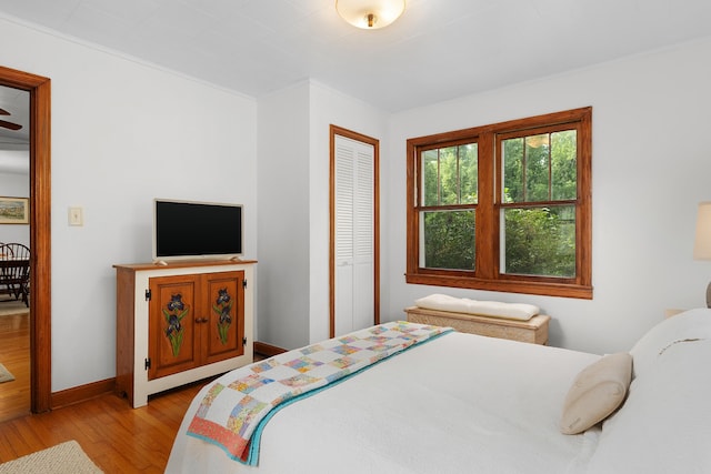 bedroom with light hardwood / wood-style floors and a closet