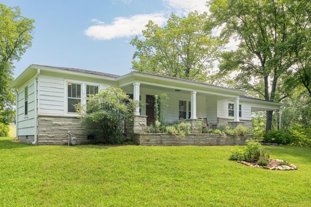 ranch-style home featuring covered porch and a front yard