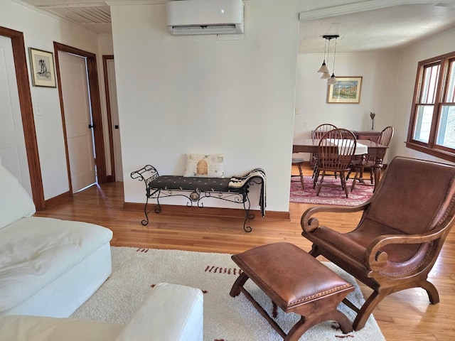 sitting room with wood-type flooring and a wall mounted air conditioner