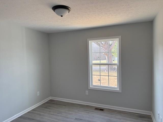 unfurnished room featuring hardwood / wood-style floors and a textured ceiling