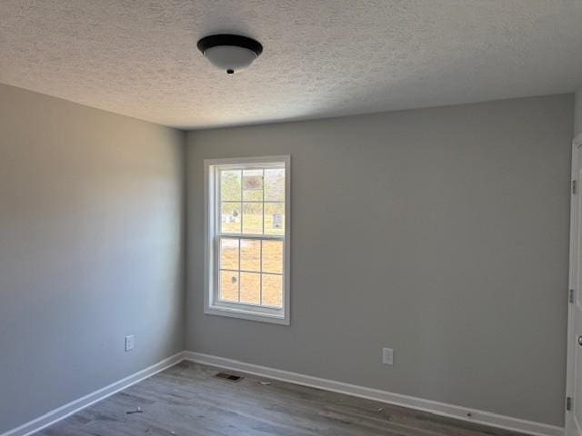 empty room featuring hardwood / wood-style floors and a textured ceiling