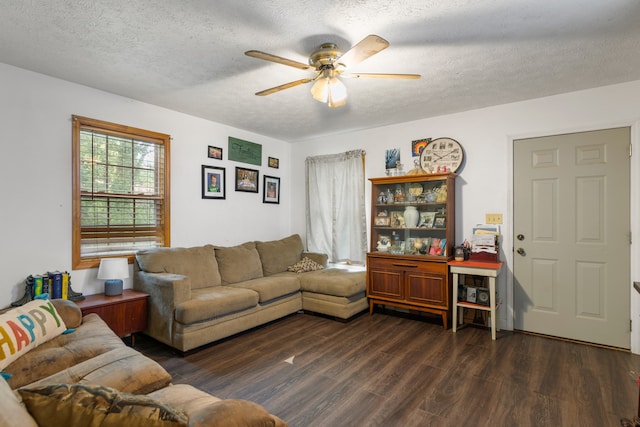 living room featuring a textured ceiling, dark wood-type flooring, and ceiling fan