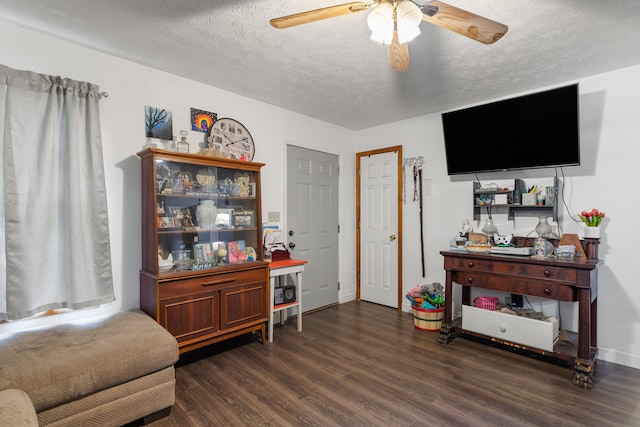 interior space featuring ceiling fan, a textured ceiling, and dark wood-type flooring