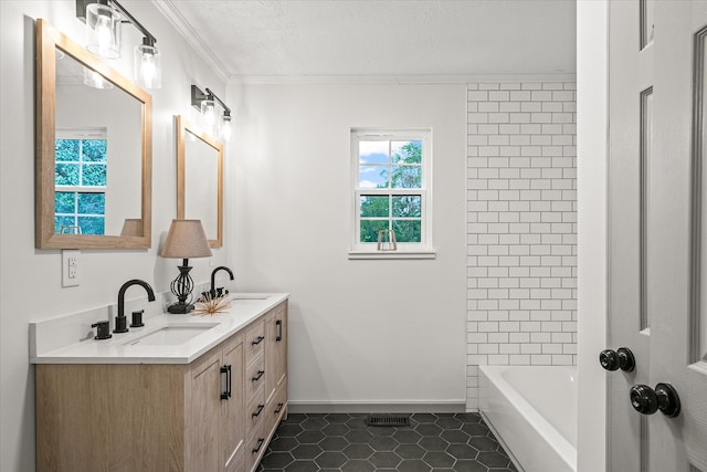 bathroom with a textured ceiling, ornamental molding, vanity, and tile patterned floors