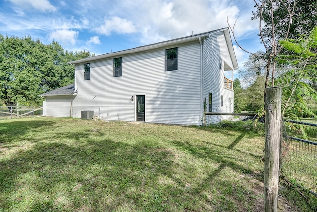 back of house featuring a lawn and central AC unit