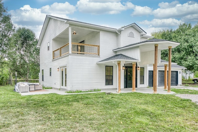 view of front facade with a garage, a balcony, a front lawn, and a patio