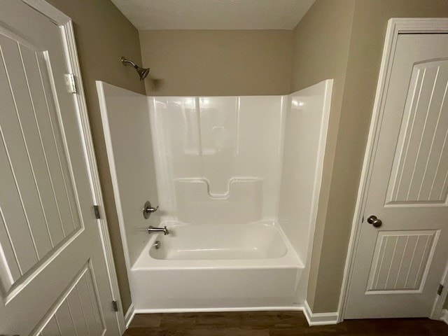 bathroom featuring bathtub / shower combination, a textured ceiling, and hardwood / wood-style flooring