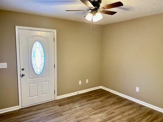 entryway featuring ceiling fan, baseboards, and wood finished floors