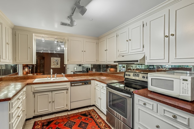 kitchen with rail lighting, white appliances, kitchen peninsula, light tile patterned floors, and sink