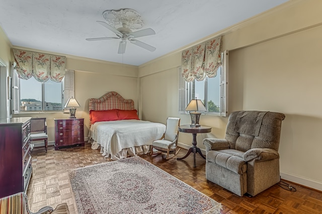 bedroom featuring multiple windows, ornamental molding, ceiling fan, and dark parquet flooring