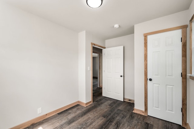 unfurnished bedroom with a closet and dark hardwood / wood-style flooring