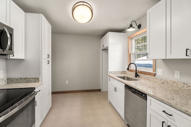 kitchen featuring white cabinets, light stone countertops, sink, and appliances with stainless steel finishes