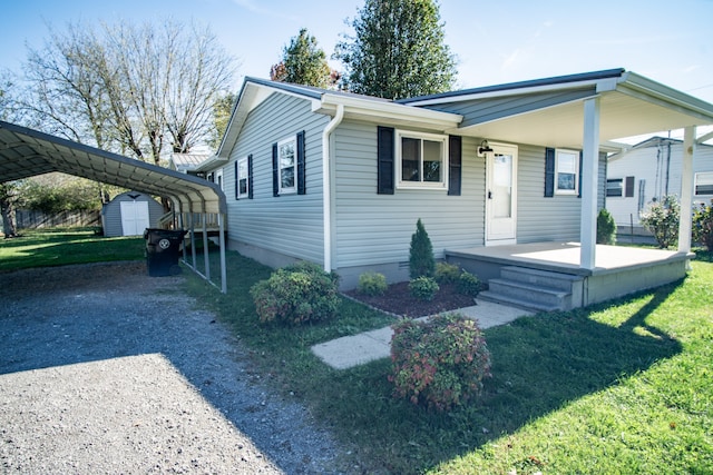 view of front facade with a shed, covered porch, a front yard, and a carport