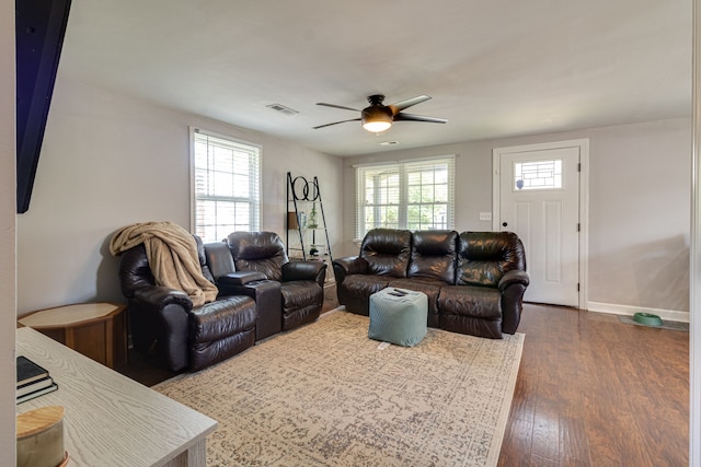 living room with ceiling fan and dark wood-type flooring