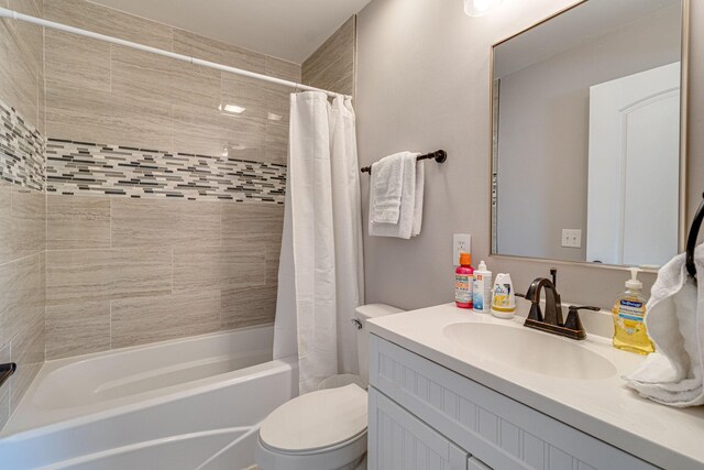 full bathroom featuring shower / bath combo with shower curtain, vanity, and toilet