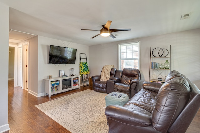 living room featuring ceiling fan and dark hardwood / wood-style flooring