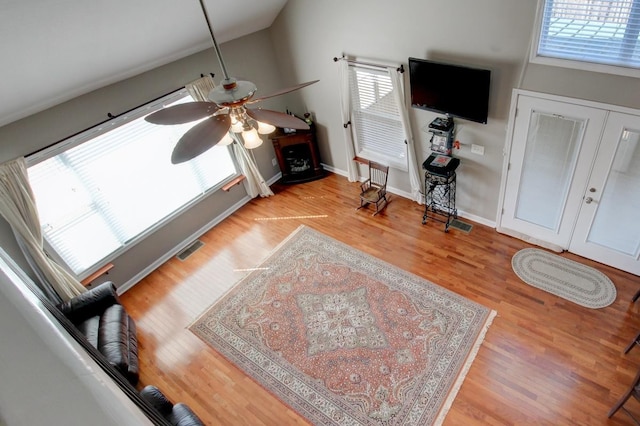 living room with ceiling fan, lofted ceiling, light hardwood / wood-style floors, and a wealth of natural light