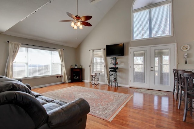 living room with plenty of natural light, ceiling fan, and high vaulted ceiling