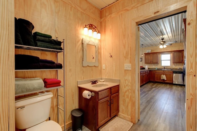 bathroom with ceiling fan, wooden walls, toilet, and wood-type flooring