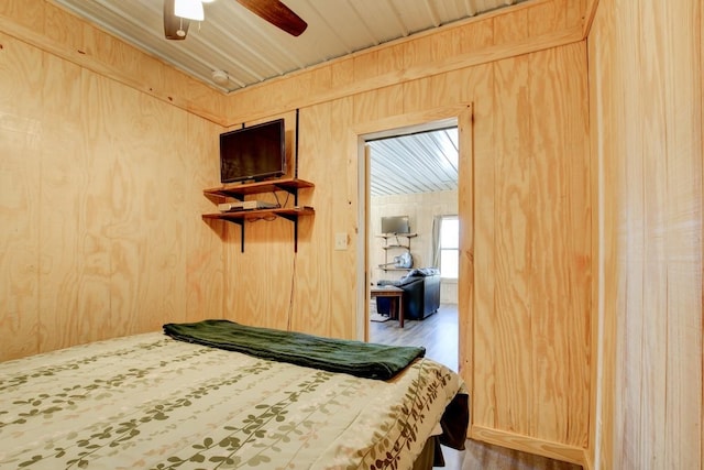 bedroom featuring wood-type flooring, wooden walls, wood ceiling, and ceiling fan