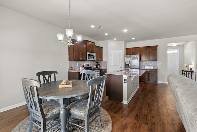 dining area with a chandelier, dark wood-type flooring, and sink