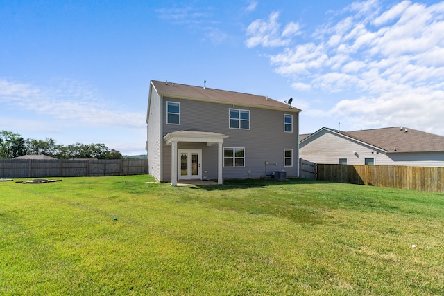 back of property with a lawn and central AC