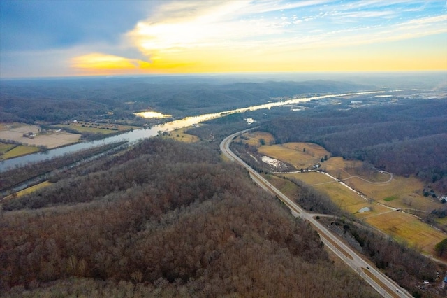 aerial view at dusk with a rural view and a water view