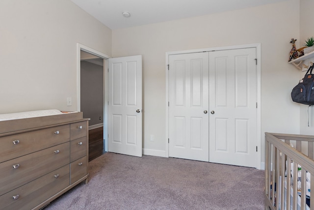 carpeted bedroom with a crib and a closet