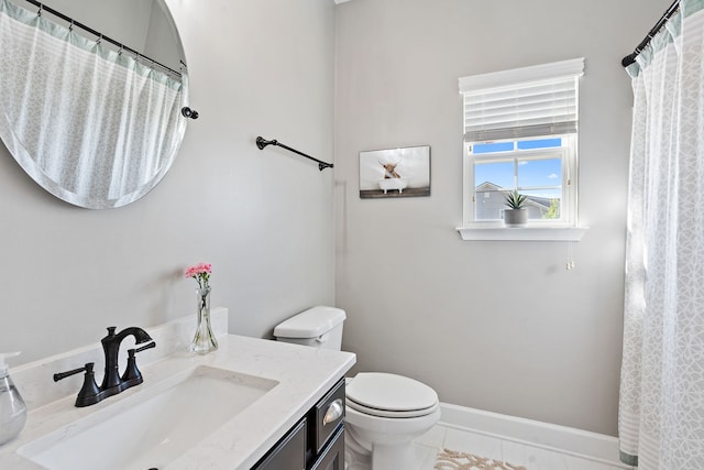 bathroom with tile patterned flooring, vanity, and toilet