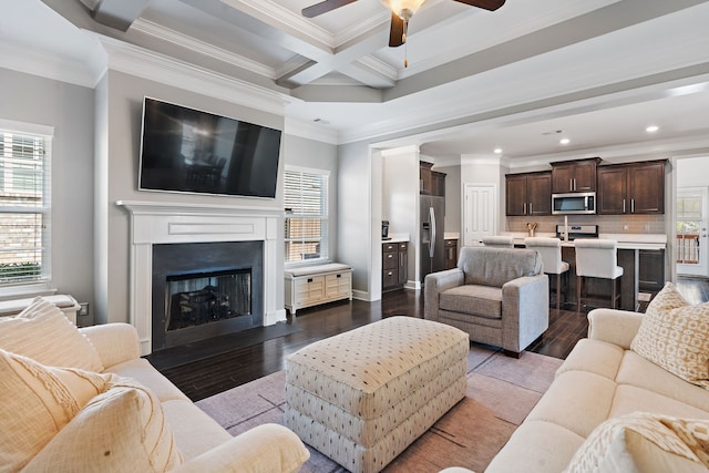 living room featuring ceiling fan, ornamental molding, hardwood / wood-style floors, and coffered ceiling