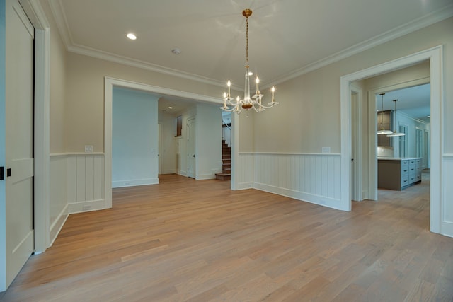 unfurnished dining area featuring crown molding, light hardwood / wood-style flooring, and a notable chandelier