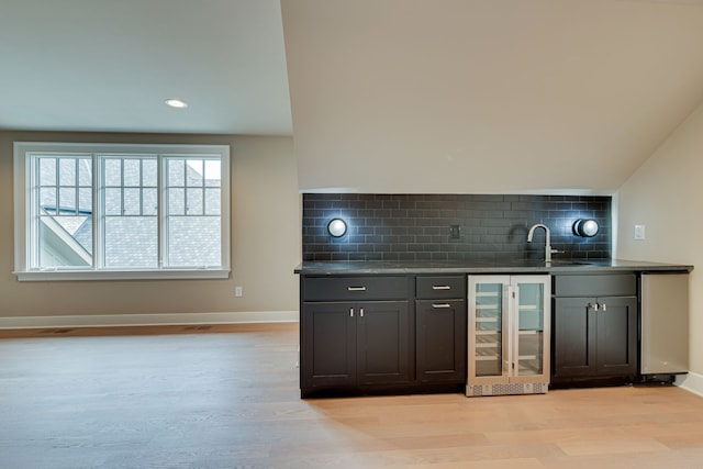 bar with wine cooler, lofted ceiling, light hardwood / wood-style floors, and tasteful backsplash