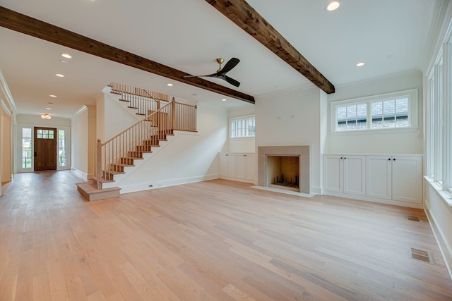 unfurnished living room with beam ceiling, crown molding, light hardwood / wood-style flooring, and a healthy amount of sunlight