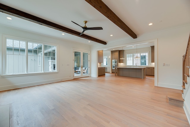 unfurnished living room with beam ceiling, sink, light wood-type flooring, and ceiling fan