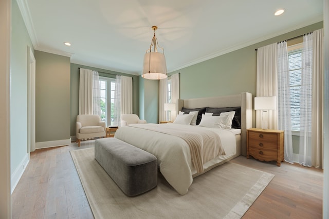 bedroom featuring light hardwood / wood-style floors, crown molding, and multiple windows