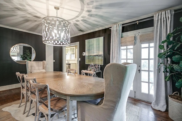 dining room featuring a healthy amount of sunlight, ornamental molding, and wood-type flooring