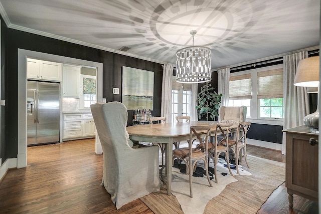 dining space featuring crown molding, light hardwood / wood-style floors, and a chandelier