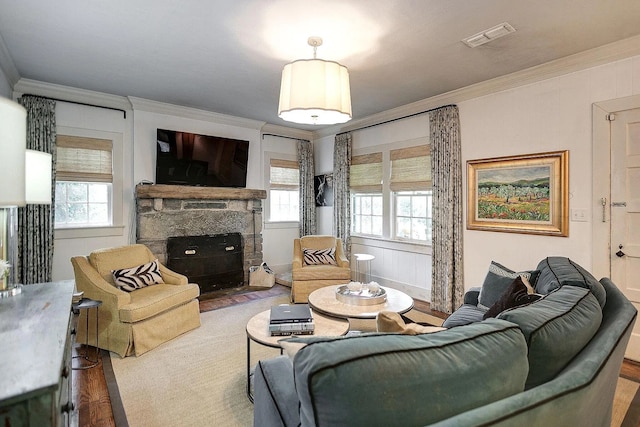 living room with hardwood / wood-style flooring, a fireplace, plenty of natural light, and crown molding