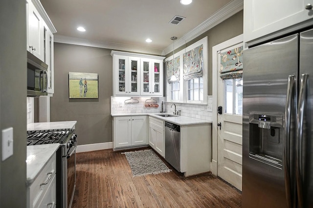 kitchen featuring light stone counters, dark hardwood / wood-style floors, white cabinets, hanging light fixtures, and stainless steel appliances