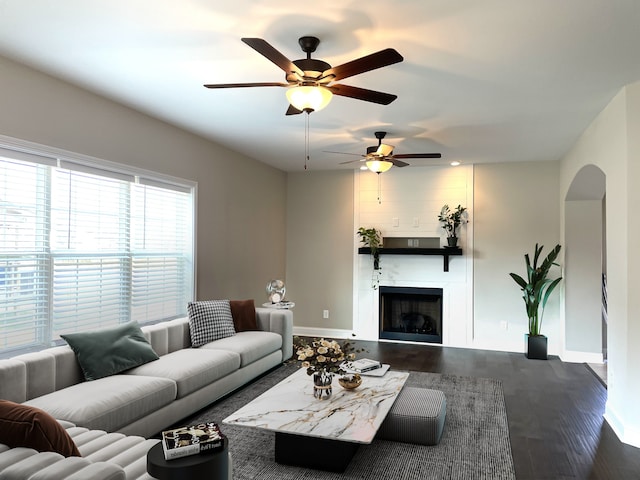 living room featuring ceiling fan and dark wood-type flooring