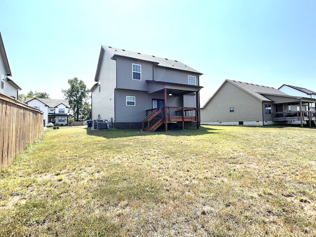 back of property with a yard, central AC, and a wooden deck