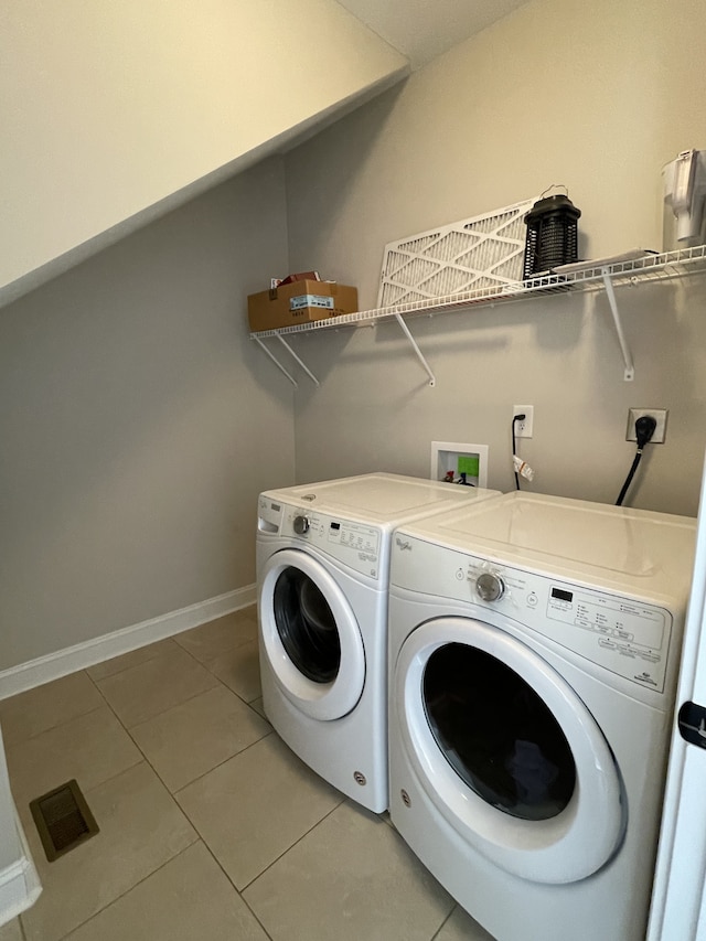 laundry room featuring washing machine and clothes dryer and tile patterned floors