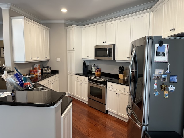 kitchen featuring white cabinets, kitchen peninsula, dark hardwood / wood-style flooring, stainless steel appliances, and crown molding