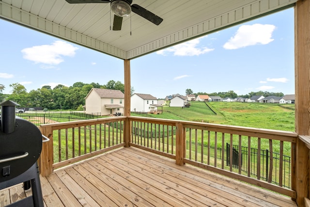 wooden terrace featuring a lawn and ceiling fan