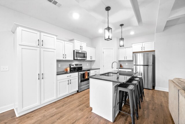 kitchen with light hardwood / wood-style flooring, stainless steel appliances, white cabinets, and sink