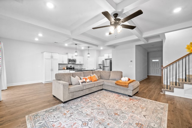 living room featuring light wood-type flooring, ceiling fan, and beamed ceiling