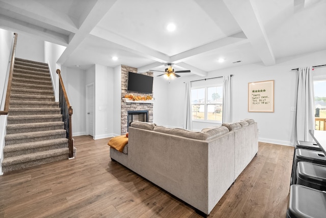 living room featuring ceiling fan, a fireplace, wood-type flooring, and a healthy amount of sunlight