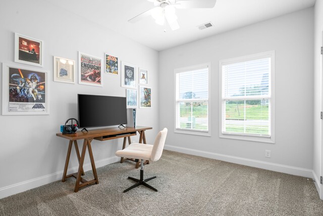 carpeted office space featuring ceiling fan