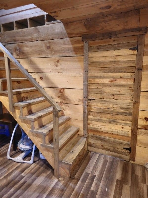 stairs with wood-type flooring and wooden walls