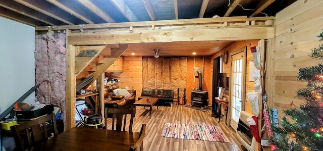 interior space featuring a wood stove, wooden walls, and wood-type flooring